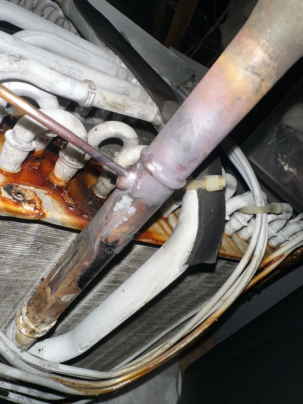 A corroded, rusted evaporator coil and drain pan